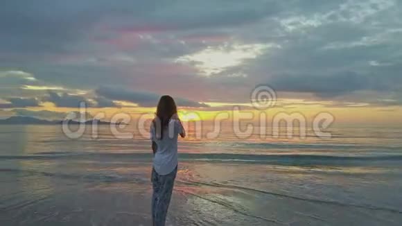 Flycam显示越南的女子在海面上拍摄黎明的录像视频的预览图