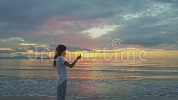 穿着白色上衣的女人在越南拍摄海洋上空的黎明视频的预览图