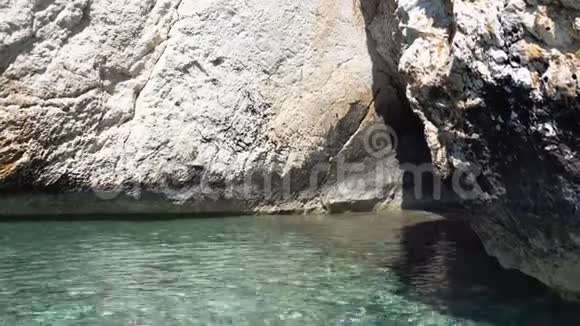 岩石背景上纯蓝色的水前往热带岛屿视频的预览图