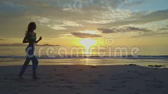 日出时女孩在沙滩上奔跑视频的预览图