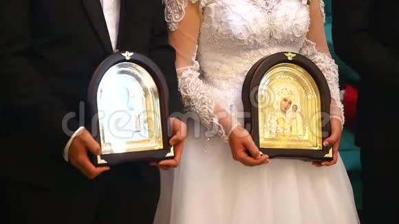 新娘和新郎在婚礼期间在教堂里举行圣像关门视频的预览图