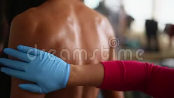 将身体油涂在女性健美运动员背部准备参加健美锦标赛视频的预览图