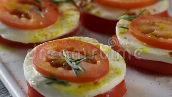 莫扎雷拉和西红柿场景新鲜番茄和马拉奶酪切片含拉和西红柿的沙拉视频的预览图
