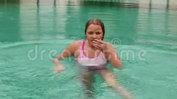 女孩在酒店游泳池里玩水孩子们在户外玩水视频的预览图