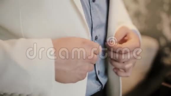 秀曼准备工作穿上他的正式西装特写男手扣一件白色夹克视频的预览图