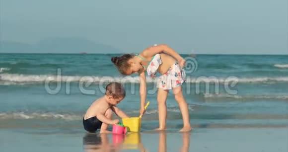 快乐无忧无虑的孩子们在海边玩沙子小朋友玩哥哥姐姐在海边玩快乐视频的预览图