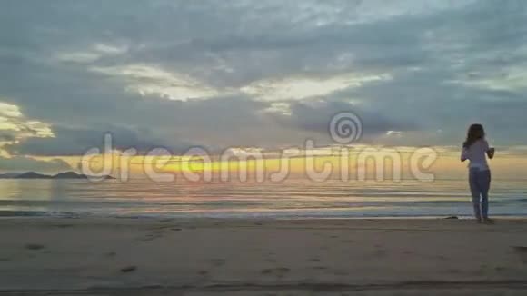 男子慢跑在沙滩上对抗海上的金色日出视频的预览图