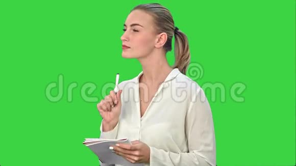 年轻的商务女性发明创意写下直到笔记本上的绿色屏幕铬键视频的预览图