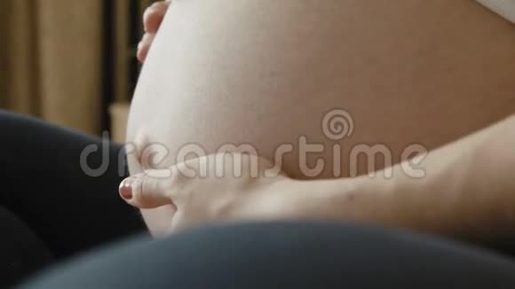 卧室里一个孕妇裸露的大肚子特写视频的预览图