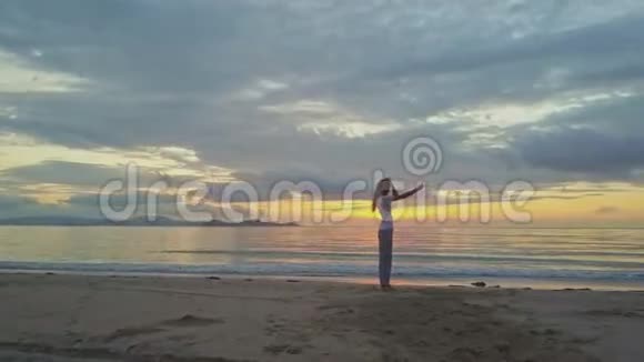 天桥风云女孩在沙滩上与金色日出做自拍视频的预览图
