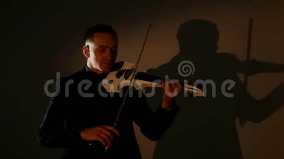 在暗室里拉小提琴的年轻人视频的预览图