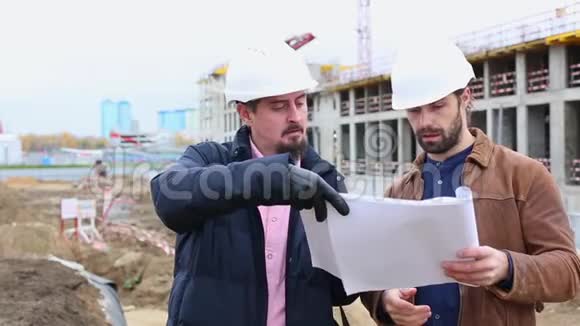 两位工程师谈论建筑工程他们看了两个纸质项目视频的预览图