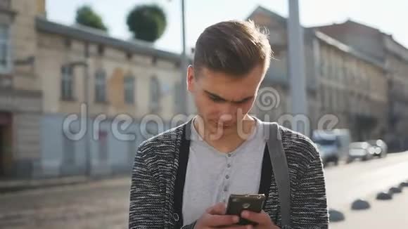 男人在街上检查他的手机视频的预览图