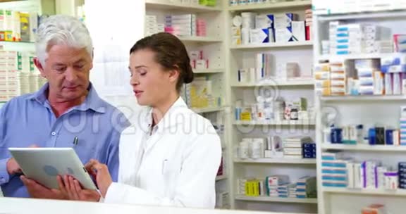 药剂师在柜台使用数字平板电脑视频的预览图