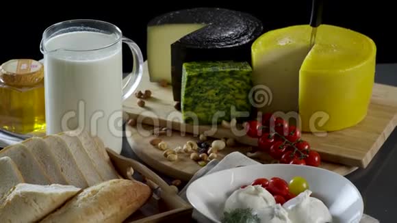 在黑色背景下一个罐子和一杯牛奶一个奶酪烤面包蜂蜜和鸡蛋的旧风格的静止生活视频的预览图