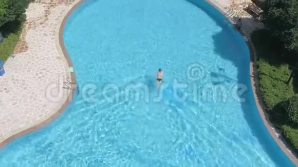 室外游泳池游泳者的慢动作鸟瞰图热带度假概念视频的预览图