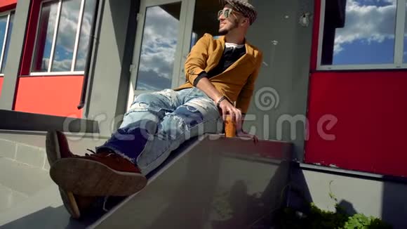 时尚界的帅哥戴着帽子戴着眼镜坐在楼梯上视频的预览图