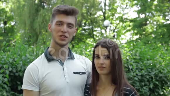 年轻夫妇微笑着和公园里的摄像机交谈视频的预览图