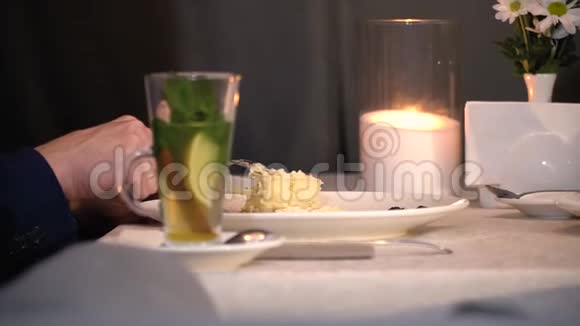 男人穿西装的手拿刀切蛋糕背景是蜡烛和雏菊有点慢动作视频的预览图