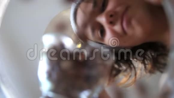 年轻女子在玻璃碗里撒榛子视频的预览图