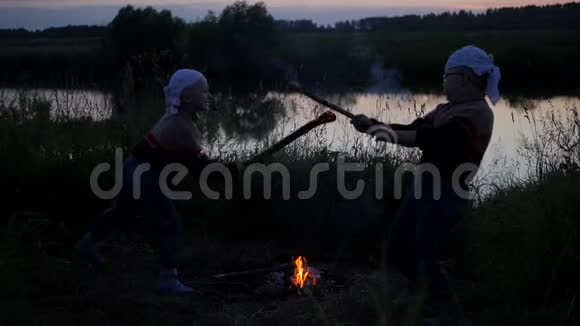从燃烧的棍子上喷出儿童之战烧死杜班卡孩子们在河的背景下战斗视频的预览图