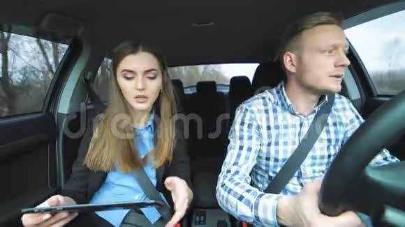男人在打电话女孩在开车时用平板电脑视频的预览图