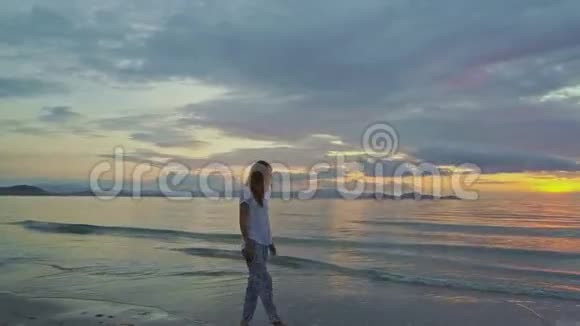 高矮女孩在海滩冲浪对抗海洋日出视频的预览图