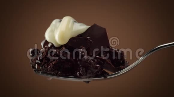 叉子上的一块巧克力蛋糕上面有慢慢移动的白色奶油视频的预览图