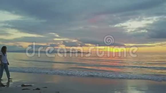 湿沙滩与海日升的瘦女孩漫步视频的预览图