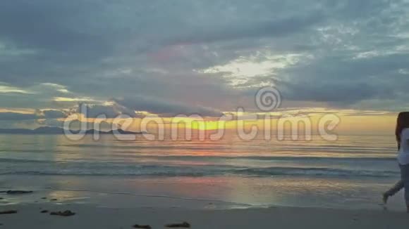 沙滩上的金色日出海洋女孩通行证相机视频的预览图