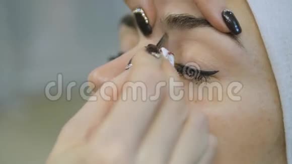 美容师双手用镊子夹在美容院妇女眉毛上视频的预览图