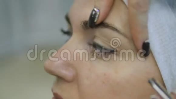 美容师双手用镊子夹在美容院妇女眉毛上视频的预览图