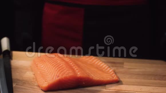 用刀在木板上特写生鱼片切制三文鱼前的多汁观赏视频的预览图