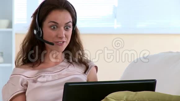 微笑的女人用电脑说话视频的预览图