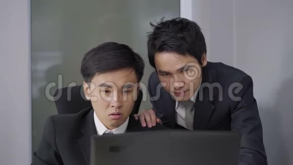 快乐的两个商人用笔记本电脑成功地完成了一个工作项目视频的预览图