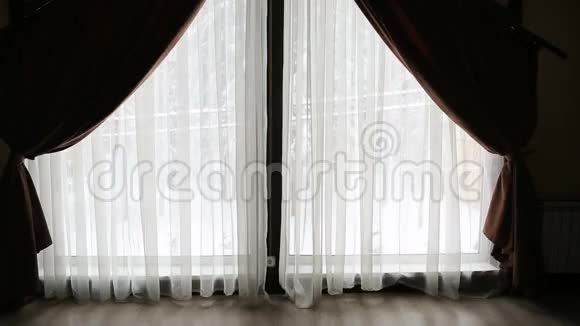 女孩用窗帘走近大窗户视频的预览图
