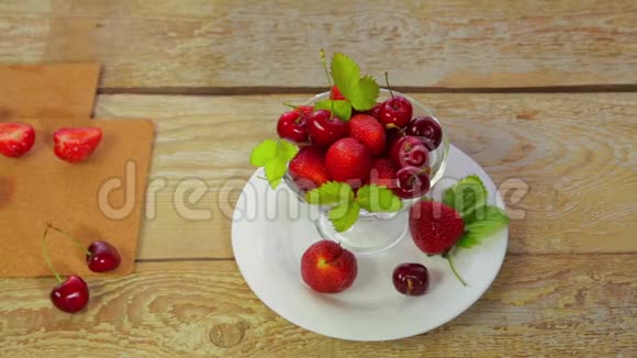 一张放在木制桌子上的白色盘子上是草莓和樱桃视频的预览图