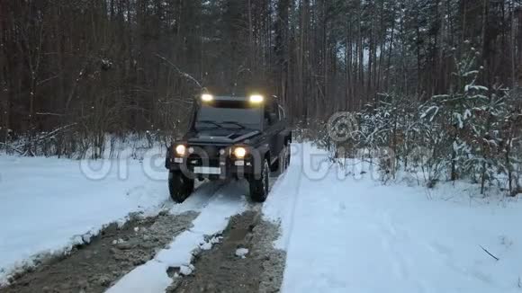 越野偷窥越野车6x6克服了一个大水坑在土路上的冬季森林视频的预览图