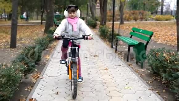 一个高加索儿童在秋季公园骑自行车视频的预览图