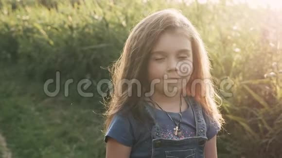 一个小女孩带着一束野花在森林里散步视频的预览图