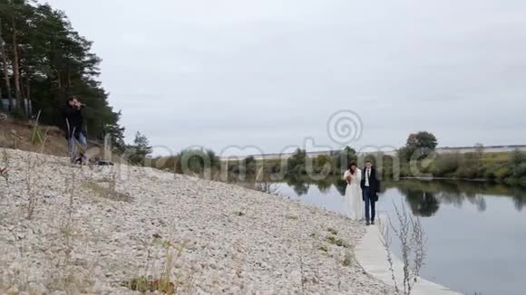 摄影师和河边的新婚夫妇视频的预览图