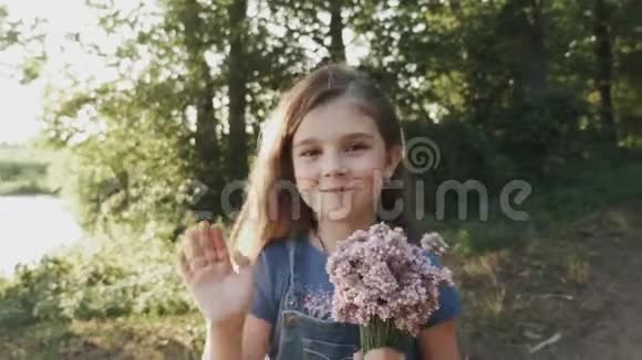 一个小女孩带着一束野花在森林里散步视频的预览图