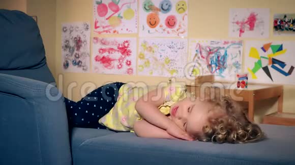 可爱疲惫的女孩睡在沙发上视频的预览图