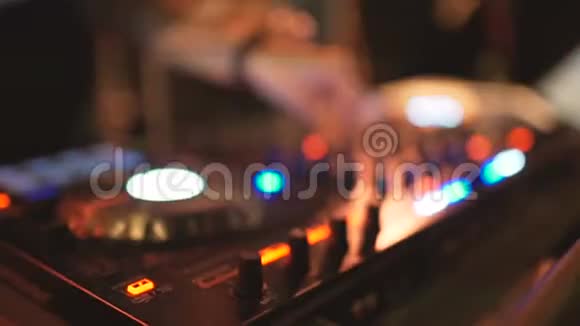 女DJ的手在夜总会的DJ甲板上调整各种轨道控制装置视频的预览图