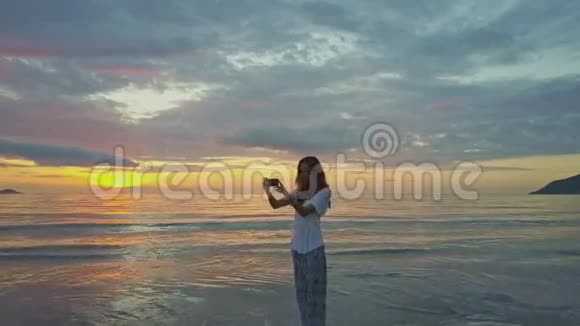 年轻女孩在海洋天际线上方的日出中自成一体视频的预览图
