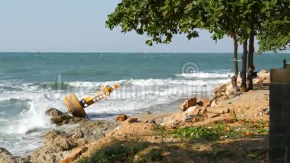 海景不错海浪拍打着石岸石岸上躺着废弃的黄色浮标有一棵树视频的预览图