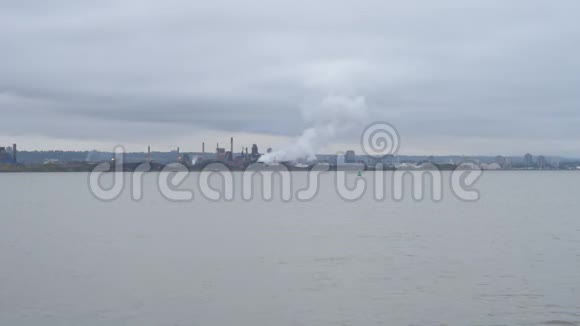 工业工厂和烟雾穿过城市附近的水视频的预览图