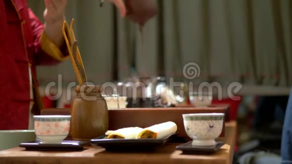 中国茶杯在锋利背景上模糊了中国传统茶饮的过程主人视频的预览图