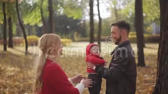 爸爸在一个秋天的公园里扔东西抓住一个小儿子视频的预览图