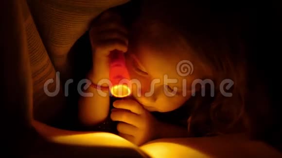 孩子用手电筒在床上看书关闭视频的预览图